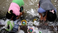 2 Orang warga tengah mencuci di Kali Sipon.