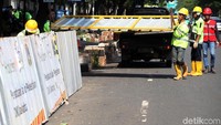 Selama proses pengerjaan, petugas memasang pagar seng.