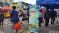  Bus hanya berhenti sebentar dan langsung mengangkut penumpang yang ingin menggunakan kendaraan itu. Kondisi cuaca juga terlihat mendung dan jalanan basah karena bekas hujan.  