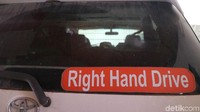 Bagian kaca belakang mobil di sebelah kanan tertulis Right Hand Driver untuk menandakan mobil dikemudikan dengan setir sebelah kanan.