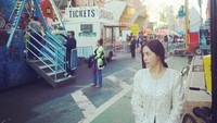 Min Hyo Rin menyempatkan datang ke taman bermain yang mirip seperti pasar malam ini. Mengenakan atasan berwarna putih dan celana pendek jeans, kecantikan naturalnya terpancar. (Instagram/Min Hyo Rin)