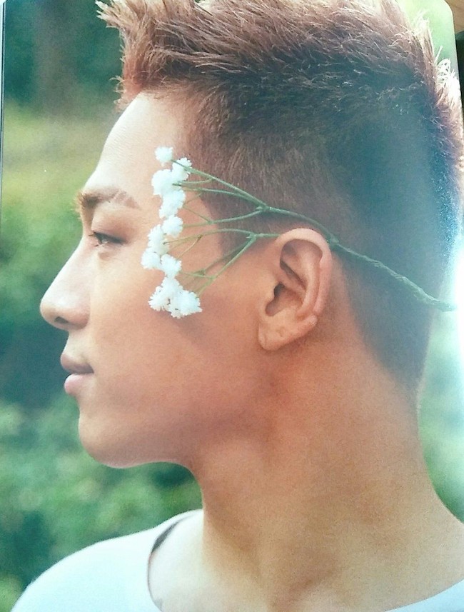 Taeyang berpose dengan sepetik bunga putih, menggambarkan nuansa rustic. Foto: dok. Dazed