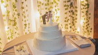 Ini dia tampilan cake simple milik pasangan Gil dan Luna. Lapisan fondant putih pada cake disempurnakan dengan cake toppers di bagian atas. Foto: Istimewa