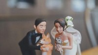 Saat dilihat lebih dekat, cake toppers ini menggambarkan Gil dan Luna yang masing-masing sedang menggendong anjing kesayangan mereka. Foto: Istimewa
