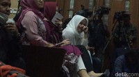 Momen Deisti mendengarkan penjelasan saksi di sidang Novanto dan menulis di buku catatan.
