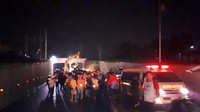 Proses evakuasi itu dibantu penerangan dari dua lampu, sementara lampu jalan mati. (Foto: Bil Wahid-detikcom)