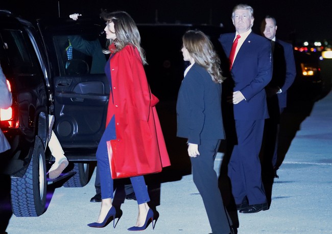 Turun dari pesawat, mantan model seksi itu terlihat mengenakan mantel merah Maison Ullens dengan Gucci tote bag berwarna senada. (Foto: Reuters)