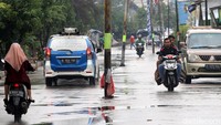 Pengendara melintas di samping tiang listrik yang berdiri di tengah jalan di kawasan Kali Baru, Bekasi, Jawa Barat, Senin (5/2/2018).