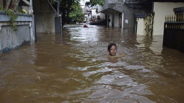 Seorang anak melintasi banjir sedalam 1,5 meter di Kelurahan Pajetan Timur, Pasar Minggu, Jakarta Selatan, Senin (5/2).