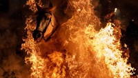 Dari foto ini bisa terlihat betapa ngerinya festival ini. Api tampak begitu panas, tapi kuda-kuda ini tetap menerjangnya. (Juan Medina/Reuters)