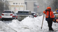 Seorang pria tengah beristirahat dari kerja keras membersihkan salju di jalanan pusat Kota Moskow (Foto: Dok. REUTERS/Sergei Karpukhin)