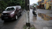 Tiang listrik itu berjejer di tengah jalan sepanjang 1,5 Km.