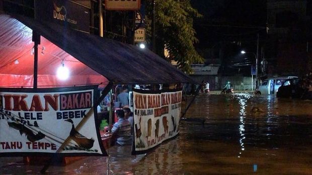 Foto makan di tengah banjir yang viral / 