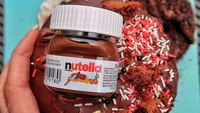 Selai cokelat nutella tidak pernah gagal menggoda. Donat yang satu ini disajikan bersama olesan selai Nutella dan taburan meises warna-warni. Lucunya, ada hiasan berbentuk kemasan Nutella di atasnya.  Foto: instagram @doughnuttime_uk