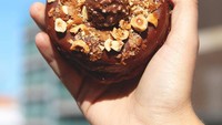 Jika mood sedang jelek, cobalah makan donat varian Rocher ini. Cokelat lezat Eropa berpadu dengan cincangan kacang hazelnut yang renyah. Lupakan diet! Foto: instagram @doughnuttime_uk