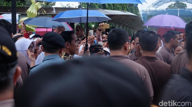 Pegang Payung Sendiri, Jokowi Ladeni Permintaan Foto Para Siswa