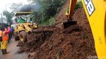 Petugas Berjibaku Membersihkan Material Longsor di Puncak