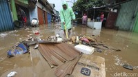 Warga membersihkan sampah yang terbawa banjir.