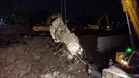 Foto: Saat ini tim masih fokus mengevakuasi mobil yang tertimbun material tembok beton dan membersihkan sisa longsoran di lokasi. (Eva-detikcom)