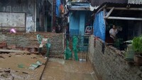 Banjir yang mulai surut menyisakan endapan lumpur. Terlihat lumpur tebal di sepanjang jalan.