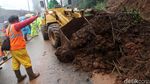 Petugas Berjibaku Membersihkan Material Longsor di Puncak