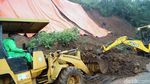 Petugas Berjibaku Membersihkan Material Longsor di Puncak