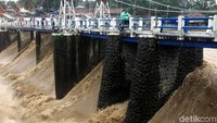 Air mengalir deras melalui pintu air Bendung Katulampa, Selasa (6/2/2018).