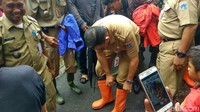 Anies menggunakan boots berwarna oranye saat akan meninjau rumah warga yang terkena banjir di Kebon Pala.