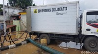 Satu mobil berlogo Dinas Pekerjaan Umum (DPU) DKI disiagakan di RT 03 RW 005 Kampung Melayu, Jakarta Timur. Mobil itu berisi pompa dan selang  untuk menyedot banjir.