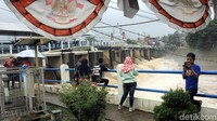 Sejumlah warga menyaksikan aliran air yang keluar dari pintu air Bendung Katulampa, Selasa (6/2/2018).
