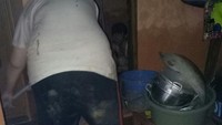 Warga terlihat mulai menyerok endapan lumpur dari dalam rumah mereka.