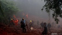 Sementara, terlihat petugas pemadam kebakaran membawa turun selang ke jurang lokasi longsor. Tebing yang longsor juga telah ditutup terpal.