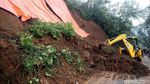 Petugas Berjibaku Membersihkan Material Longsor di Puncak