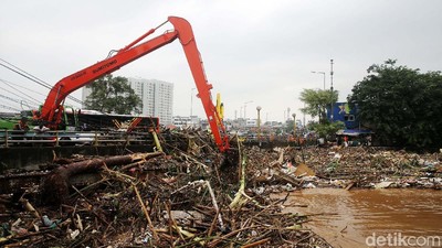 Terbawa Banjir, Sampah Batang Kayu Menumpuk di Jembatan