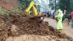 Petugas Berjibaku Membersihkan Material Longsor di Puncak