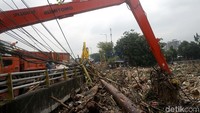 Sampah yang terbawa banjir di sungai Ciliwung diangkut dengan truk.