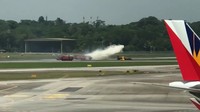 Petugas memadamkan api di pesawat. Pilot mengalami luka-luka ringan dan kini menjalani perawatan (Foto: Screenshot video via Channel News Asia)