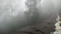 Jalan yang longsor dekat objek wisata Riung Gunung ditutup terpal dan karung pasir (Haris/detikTravel)