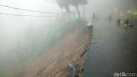 Ada pula retakan di aspal serta tanah sisi kiri jalan yang longsor.