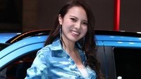 Seorang SPG tersenyum di samping mobil modifikasi berwarna biru. Foto: Response