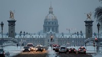 Hujan salju lebat yang mengguyur Paris, Prancis mengganggu aktivitas publik. Foto menunjukkan lalu lintas di jembatan Pont Alexandre III, dekat Invalides Hotel, Paris yang diselimuti salju tebal pada Rabu (7/2) pagi. Foto: REUTERS/Gonzalo Fuentes