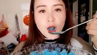 Wah, ini sih balok es yang biasa ada di dalam kulkas Anda! Sepertinya sudah dicampur sirup jadi warnanya biru. Wanita ini dengan santai melahap es batunya dengan sendok. Kaya makan nasi aja! Foto: Istimewa