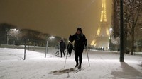 Seorang warga tampak menggunakan peralatan ski untuk beraktivitas di Champ de Mars, dekat Menara Eiffel yang ikonik. Foto: REUTERS/Gonzalo Fuentes