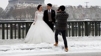Paris diselimuti salju setebal 12 cm. Meski begitu, dua sejoli ini asyik melangsungkan sesi foto untuk pernikahannya. (Foto: REUTERS/John Schults)