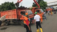 Truk-truk pengangkut sampah berbaris di sisi ekskavator. Truk-truk berwarna oranye itu akan langsung pergi bila baknya sudah penuh dengan sampah. Foto: (Elza Astari Rd/detikcom)