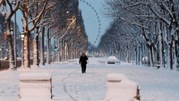 Jalan-jalan di Paris dan sekitarnya tertutup salju hingga setebal 12 cm. Terlihat seorang warga berjalan di Champs-Elysees avenue yang diselimuti salju tebal. Foto: REUTERS/Gonzalo Fuentes