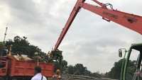 Operator ekskavator merupakan petugas terlatih. Dalam waktu singkat, bak sampah di truk-truk cepat terisi. Foto: (Elza Astari Rd/detikcom)