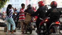 Pengendara motor memberikan sumbangannya.