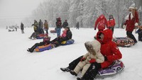Meksi diselimuti salju tebal, tapi ada juga yang bersyukur dari kondisi ini. Siapa lagi kalau bukan anak-anak yang main seluncuran es di taman kota saat akhir pekan (dok. Mikhail Japaridze/TASS)