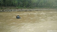 Potret anak-anak sekolah menyeberangi sungai yang alirannya cukup deras.
